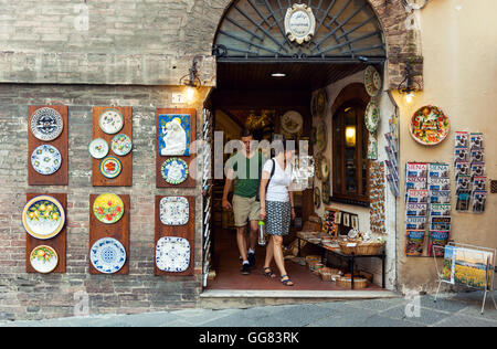 Tourists visiting traditional art and souvenir shop in old town of Siena, Italy Stock Photo