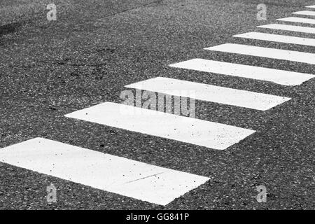 Pedestrian crossing road marking zebra, white rectangles over gray asphalt pavement, photo with selective focus Stock Photo
