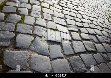 Old dark gray shining cobblestone road background photo, vintage toned photo Stock Photo