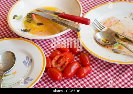 fresh piccadilly tomatoes on a table with dirty plates Stock Photo