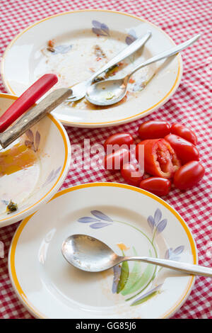 fresh piccadilly tomatoes on a table with dirty plates Stock Photo