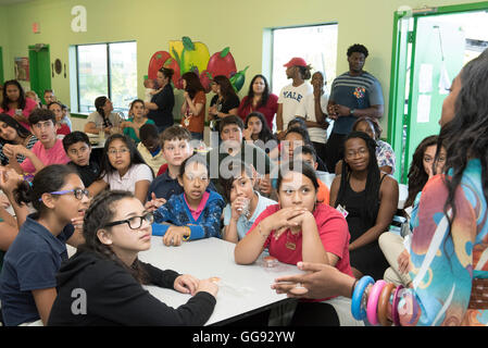 Multi-ethnic group of junior high students congregate in school cafeteria during after-school Earth Day program Stock Photo