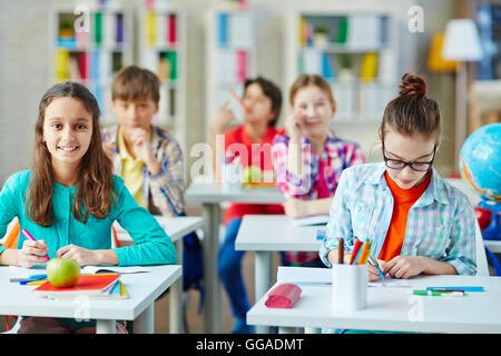 Portrait of cheerful pupil girl studying in school class Stock Photo ...