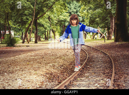 A little girl balancing on the rails. Stock Photo