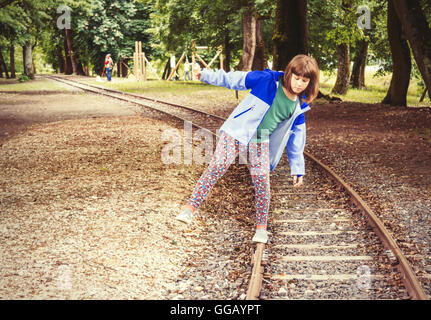 A little girl balancing on the rails. Stock Photo