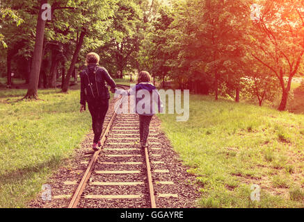 a little girl and his mother balancing on the rails. Stock Photo