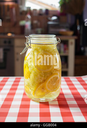 Fresh elderflower syrup in a buckled glass. Stock Photo