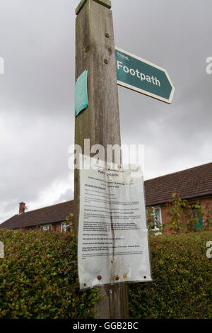 On a wooden footpath sign a planning Public Inquiry notice Stock Photo