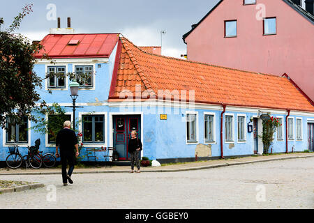 Ystad, Sweden - August 1, 2016: Old blue house in the corner of a street (Pilgrand) in the city. Small table and chairs under wi Stock Photo