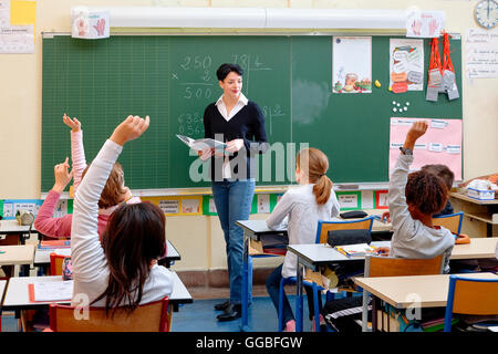 Portrait of diligent schoolkids and their teacher talking at lesson Stock Photo