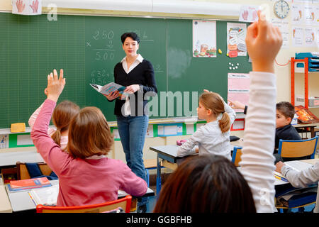 Portrait of diligent schoolkids and their teacher talking at lesson Stock Photo