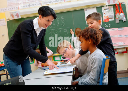 Portrait of diligent schoolkids and their teacher talking at lesson Stock Photo