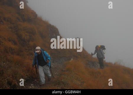 View  of Sherpa on route up Zatrwa La Pass in mist Stock Photo