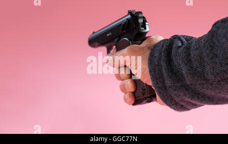 Gun in man hand on pink background Stock Photo