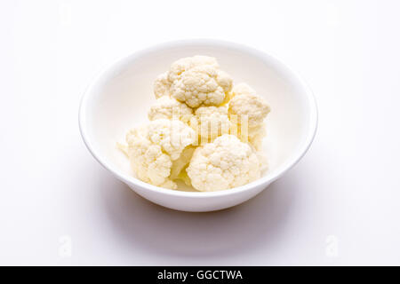 Fresh cauliflower in white bowl colander on a white surface Stock Photo