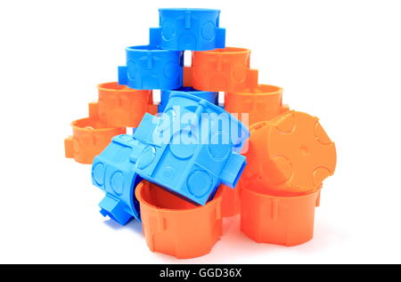 Blue and orange plastic electrical boxes on white background, components for use in electrical installations, Stock Photo