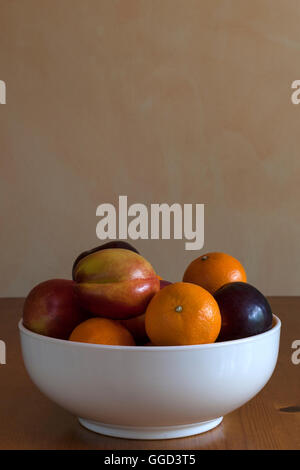 Fruit in bowl on kitchen table Stock Photo