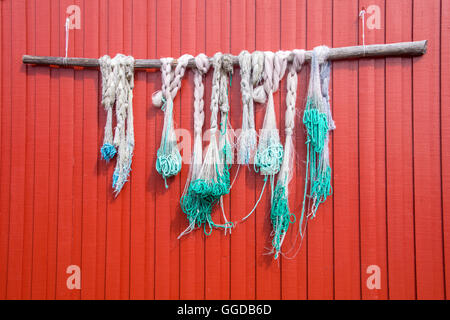 Fishing nets blue green hanging on the red painted wooden wall Stock Photo