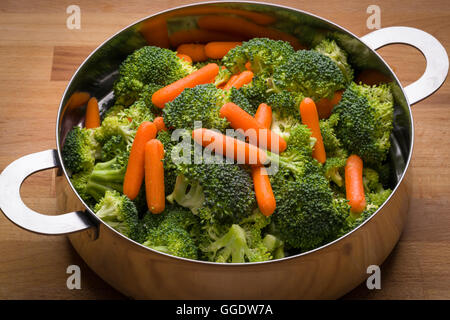Fresh broccoli and carrots in stainless steel colander Stock Photo