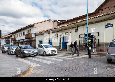 Cusco, Peru - May 12 : Police woman directing traffic on a busy intersection at rush hour in Cusco. May 12 2016, Cusco Peru. Stock Photo