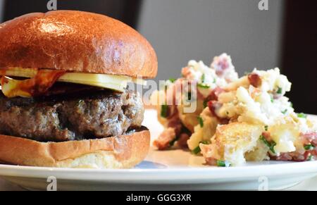 Cheese burger and potato salad on a white plate, Stock Photo