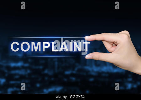 hand pushing complaint button on blurred blue background Stock Photo