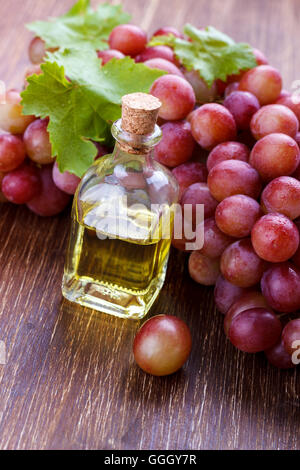 Small bottle with grape seed oil on a wooden table,selective focus Stock Photo