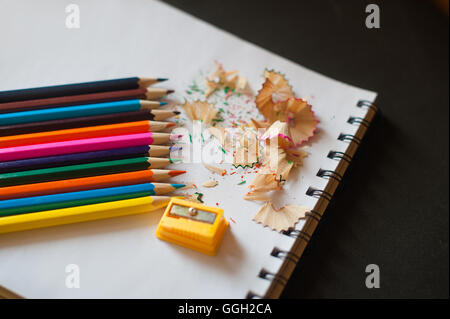 sharpened colored pencils, sharpener and shavings Stock Photo