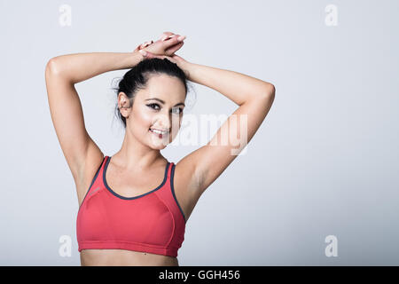 Woman in her 20s in fitness gear working out and exercising. Stock Photo