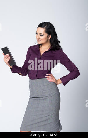 Smiling woman in business attire using a tablet to do her work Stock Photo