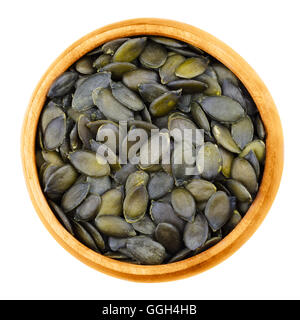 Pepita pumpkin seeds in a bowl on white background. Flat green edible summer squash seeds. Stock Photo