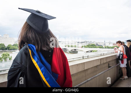 Graduation day - a young university graduate wearing a mortarboard looks towards future horizons from the Royal Festival Hall, London, England, U.K. Stock Photo