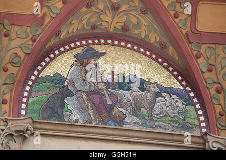 Allegory of sheep farming in Slovakia depicted as a shepherd tending a herd of sheep. Allegorical mosaic after design by Czech artist Mikolas Ales on the Zemska Bank Building in Prague, Czech Republic. The building of the Zemska Bank, later used by the Zivnostenska Bank, was designed by Czech architect Osvald Polivka and built in 1894-1896 in Na Prikope Street. Stock Photo