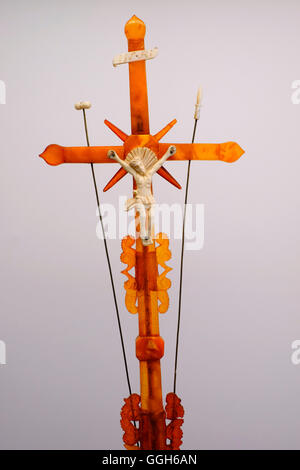 A cross with the figure of Jesus Christ crucified upon it made of modified amber displayed at the Amber museum inside the the Tyszkiewicz Palace in the seaside resort town of Palanga, Lithuania. The Baltic region is home to the largest known deposit of amber. It dates from 44 millions years ago and includes the most species-rich fossil insect fauna discovered to date. Stock Photo