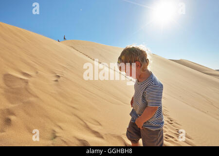 Boy in a sand dune, Dune 7, Walvis Bay, Erongo, Namibia Stock Photo