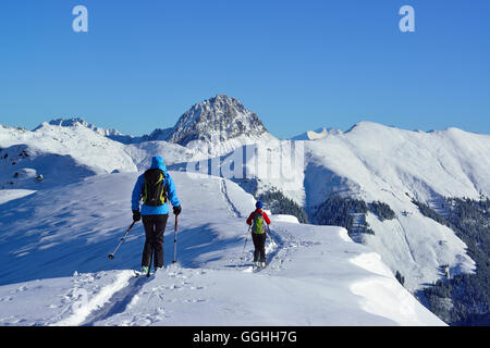 Two female back-country skiers downhill skiing from mount Steinberg, Kitzbuehel Alps, Tyrol, Austria Stock Photo