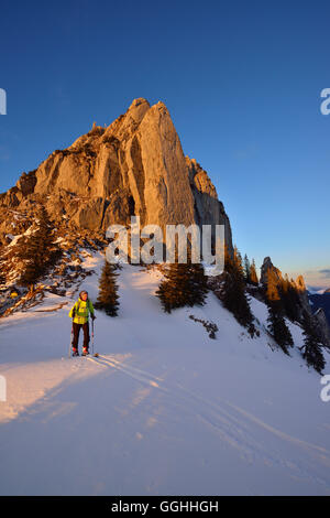 Female back-country skier ascending to Risserkogel, Blankenstein in background, Bavarian Prealps, Upper Bavaria, Germany Stock Photo