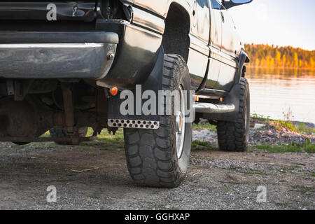 Black SUV car fragment. Still lake coast on a background Stock Photo