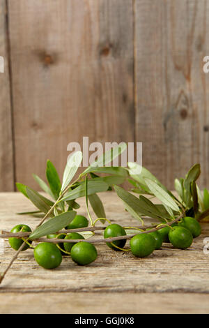 Olive oil and olive branch on the wooden table Stock Photo - Alamy