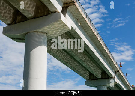 Low angle view of the flyover above the lake of Cingoli against blue sky. Light reflection on the concrete structure. Stock Photo