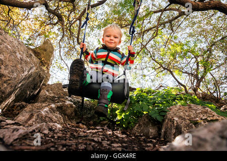 Boy (2 years) swinging, Taormina, Messina, Sicily, Italy Stock Photo