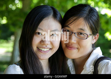 Two young women smiling at camera, Leipzig, Saxony, Germany Stock Photo