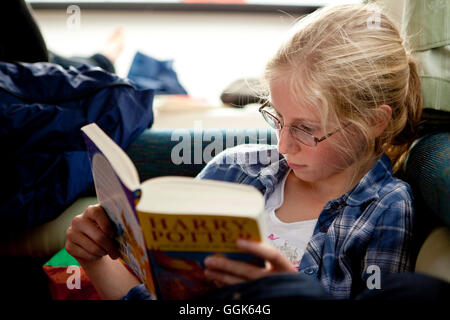 Young girl reading Harry Potter book intensely, Athlone, County Offaly, Ireland, Europe Stock Photo