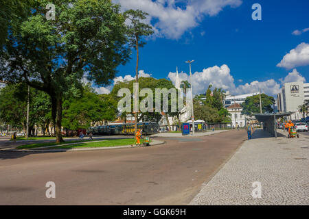 CURITIBA ,BRAZIL - MAY 12, 2016: pedestrians walking arround the bus station surrounded by big trees Stock Photo