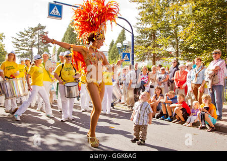 A young boy looking up to a beautiful female samba dancer wearing feather costume during the Samba Festival in Bad Wildungen, Ba Stock Photo