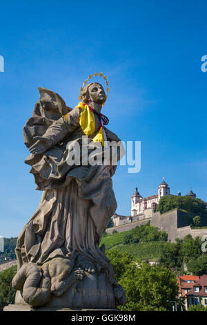 Statue on Alte Mainbruecke bridge across the Main river with Marienberg fortress on the hillside, Wuerzburg, Franconia, Bavaria, Stock Photo