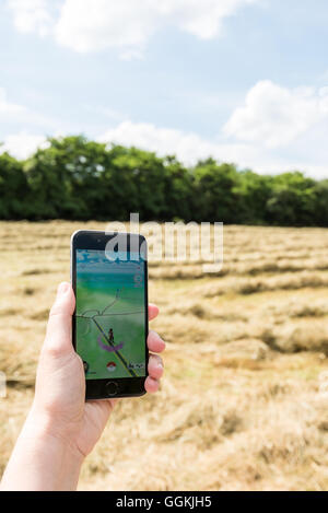 Ostfildern, Germany - July 17, 2016: A woman is playing the augmented reality smartphone app 'Pokemon GO' on her iPhone while ou Stock Photo