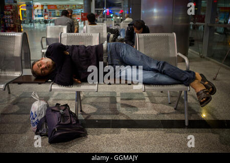 A man sleeps on a bench at Kayseri Bus Terminal, Turkey. © Jordi Boixareu Stock Photo
