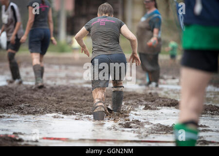 Woellnau, Germany. 06th Aug, 2016. Participants in the German Championship in Mud Soccer sink ankle-deep into a ploughed and watered field in Woellnau, Germany, 06 August 2016. The winners of the playful championship qualify for the World Championship in Finland. Photo: ALEXANDER PRAUTZSCH/dpa/Alamy Live News Stock Photo