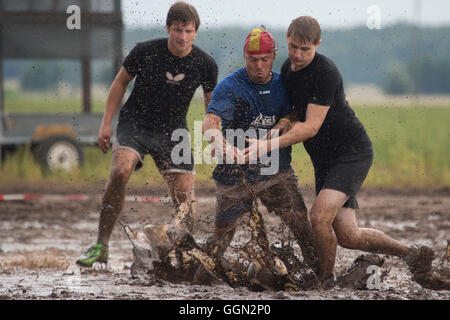 Woellnau, Germany. 06th Aug, 2016. Participants in the German Championship in Mud Soccer sink ankle-deep into a ploughed and watered field in Woellnau, Germany, 06 August 2016. The winners of the playful championship qualify for the World Championship in Finland. Photo: ALEXANDER PRAUTZSCH/dpa/Alamy Live News Stock Photo